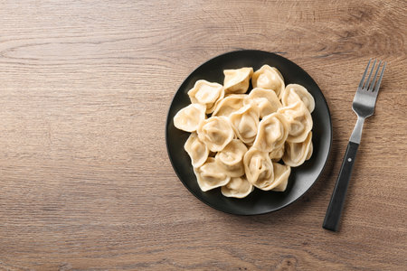 Tasty dumplings on wooden table, flat lay. Space for textの写真素材
