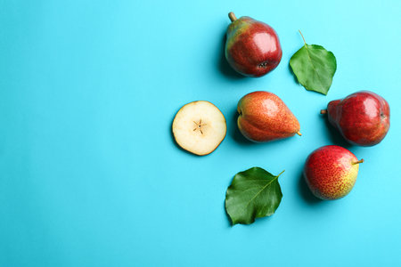 Ripe juicy pears on blue background, flat lay. Space for textの写真素材