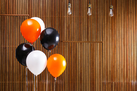 Colorful balloons against wooden wall, space for text. halloween partyの写真素材