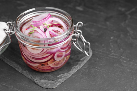 Jar of pickled onions on gray table. Space for textの写真素材
