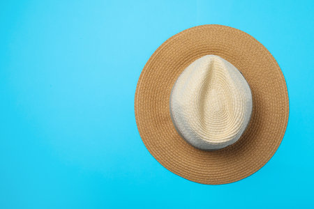 Stylish straw hat on blue background, top view. Space for textの写真素材