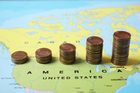 Different stacks of coins near USA on world mapの写真素材
