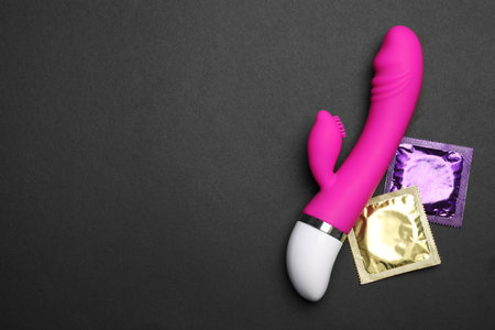 Vibrator and condoms on black background, top view with space for text. sex gamesの写真素材