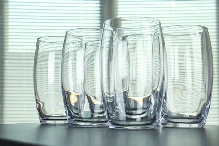 Empty glasses on gray table against blurred background, closeupの写真素材