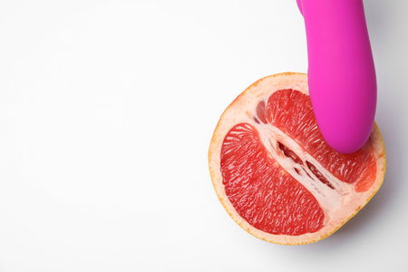 Half of grapefruit and purple vibrator on white background, top view. sex conceptの写真素材