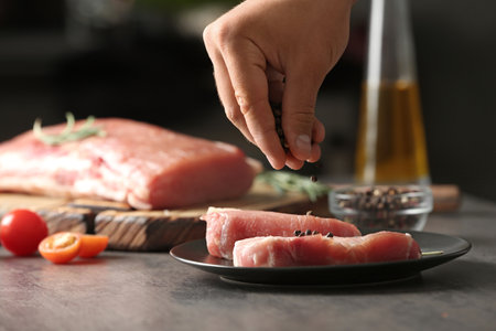 Man cooking fresh raw meat on gray table, closeupの写真素材