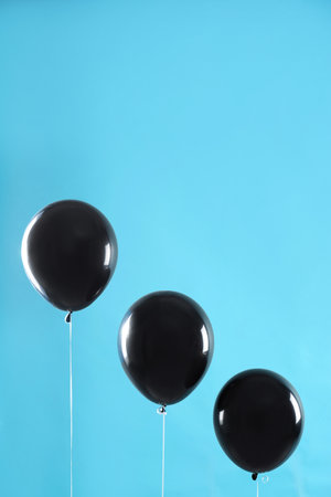 Black balloons on blue background, space for text. halloween partyの写真素材