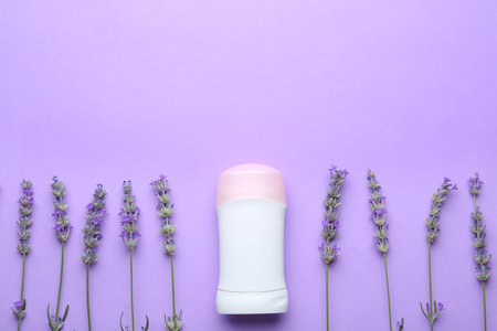 Female deodorant and lavender flowers on lilac background, flat layの写真素材