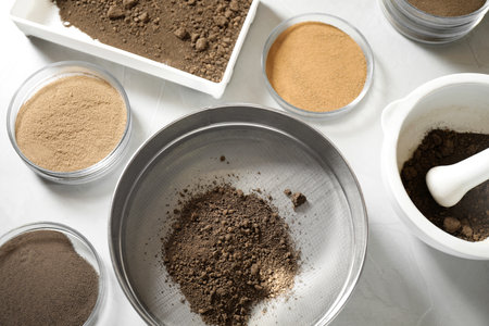 Laboratory equipment for pulverizing and sieving of soil samples on light table, flat lay