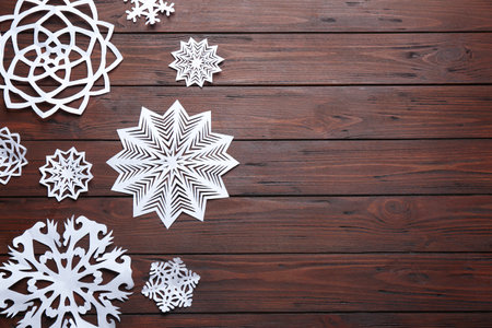 Flat lay composition with paper snowflakes on wooden background, space for text. winter seasonの写真素材