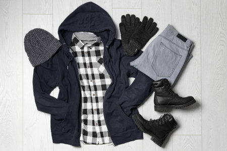 Flat lay composition with winter clothes and boots on white wooden backgroundの写真素材