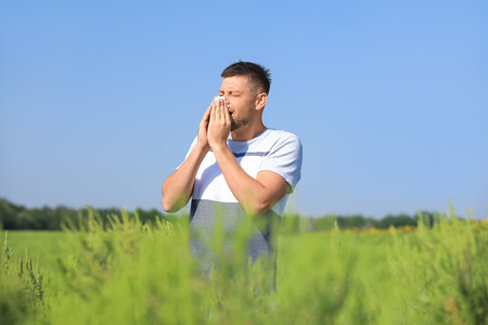 Man suffering from ragweed allergy outdoors on sunny dayの写真素材