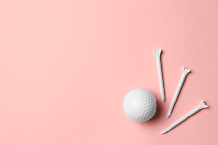 Golf ball and tees on pink background, flat lay. Space for textの写真素材