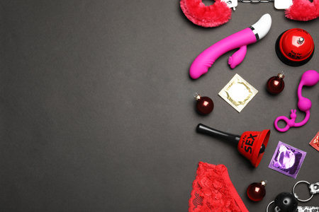 Different sex toys on black background, flat lay. Space for textの写真素材