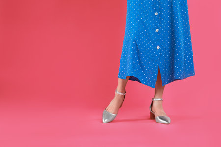 Woman in stylish shoes on pink background. Space for textの写真素材