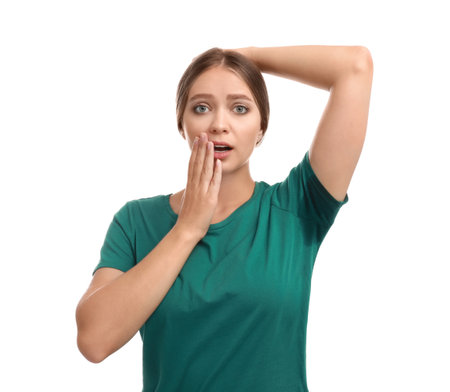 Young woman with sweat stained on her clothes against white background. Using deodorantの写真素材