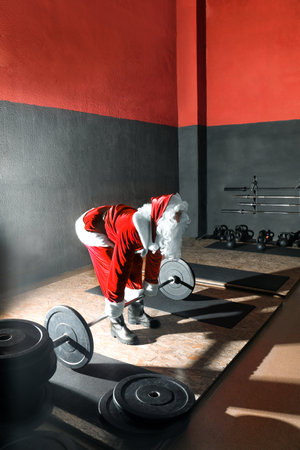 Young Santa Claus training in modern gymの写真素材