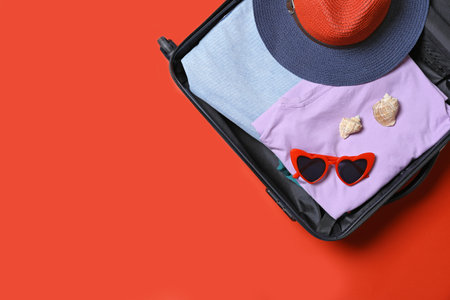 Suitcase with beach accessories on red background, top view. Space for textの写真素材