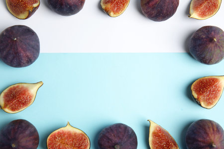 Frame made with fresh figs on color background, top view. Space for textの写真素材