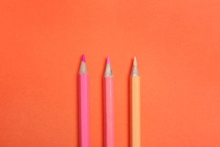 Color pencils on coral background, flat layの写真素材