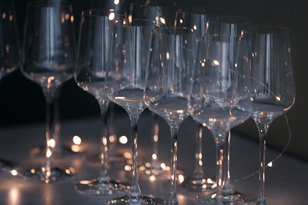 Empty clean glasses and fairy lights on tableの写真素材