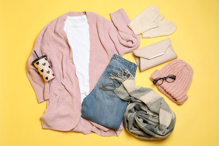 Flat lay composition with winter clothes and glasses on yellow backgroundの写真素材