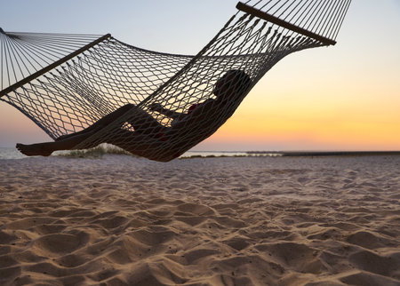 Young woman relaxing in hammock on the beachの写真素材