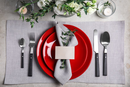 Elegant festive table setting with blank card on gray background, flat layの写真素材