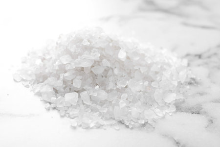 Pile of white sea salt on marble table, closeup. spa treatmentの写真素材