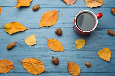 Flat lay composition with cup of hot drink on blue wooden table. Cozy autumn atmosphereの写真素材