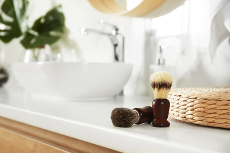 Shaving brushes on light countertop in bathroomの写真素材
