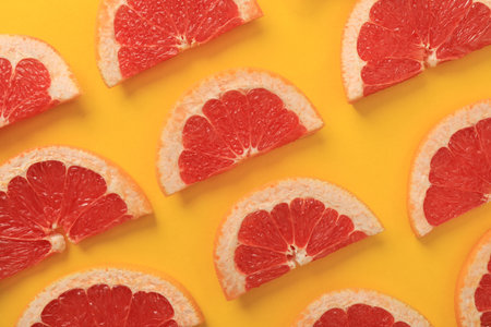 Flat lay composition with slices of juicy grapefruit on yellow backgroundの写真素材