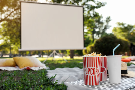 Popcorn and drink on green grass in open air cinema. Space for textの写真素材