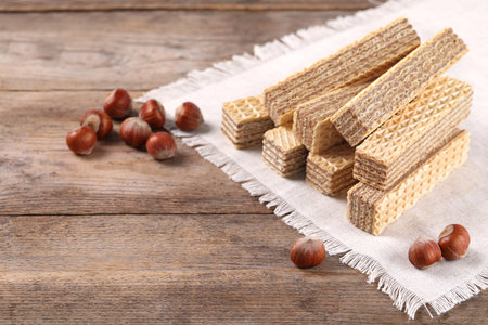Delicious wafers with hazelnuts on brown wooden backgroundの写真素材
