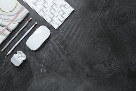 Flat lay composition with computer keyboard and notebook on gray background, space for text. Graphic...