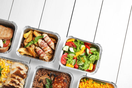 Lunchboxes on white wooden table, flat lay. Healthy food deliveryの写真素材