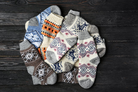 Different knitted socks on black wooden background, flat layの写真素材