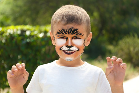 Cute little boy face painting outdoors