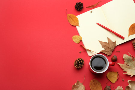 Flat lay composition with cup of hot drink on red background, space for text. Cozy autumn atmosphere