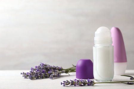 Female deodorants and lavender flowers on white wooden table. Space for textの写真素材
