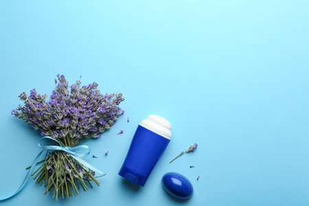 Female deodorant and lavender flowers on light blue background, flat layの写真素材