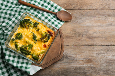 Flat lay composition with tasty broccoli casserole on wooden table. Space for textの写真素材