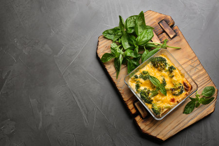 Tasty broccoli casserole in baking dish on gray table, top view. Space for textの写真素材