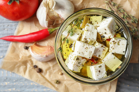 Composition with pickled feta cheese in jar on gray wooden table, top viewの写真素材