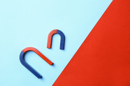 Red and blue horseshoe magnets on color background, flat lay. Space for textの写真素材