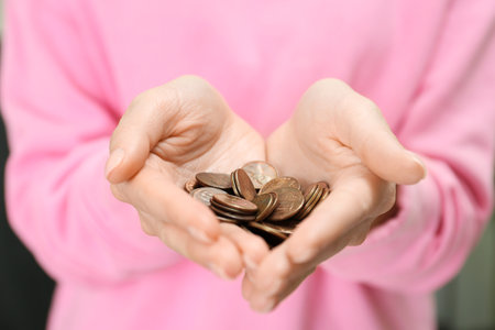 Woman holding pile of coins, closeup view