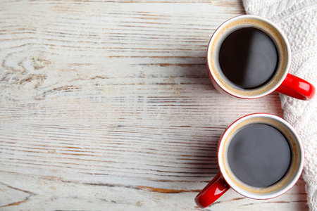 Flat lay composition cups of hot coffee and blanket on wooden background, space for text. winter drinkの写真素材