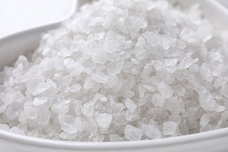Natural white sea salt in bowl, closeup view. spa treatment