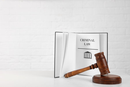 Book with words CRIMINAL LAW and gavel on table against white background. Space for textの写真素材
