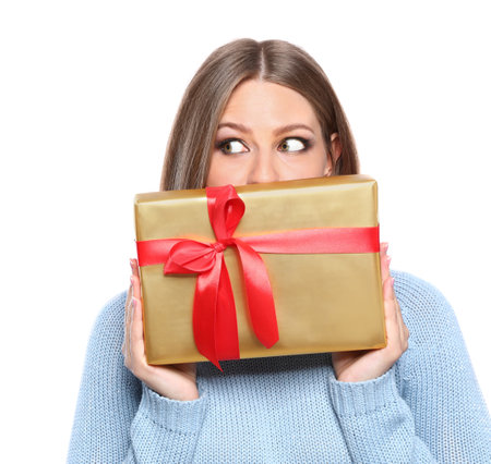 Emotional young woman with Christmas gift on white backgroundの写真素材
